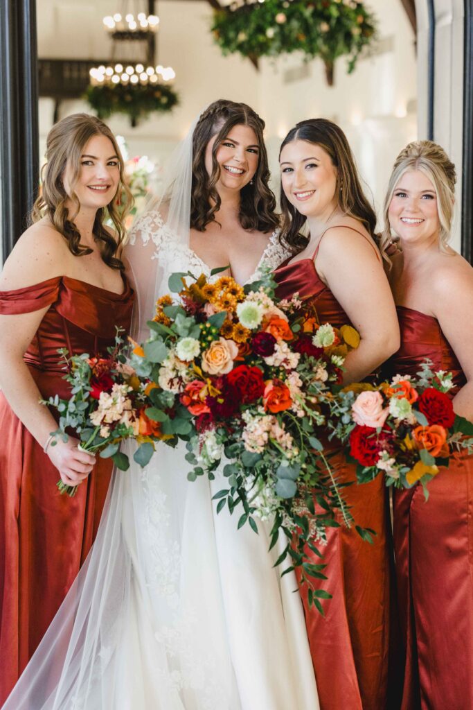 Bride and bridesmaids smiling and holding their gorgeous bouquets. 