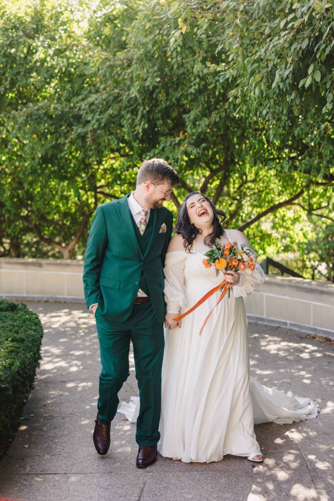 Bride and groom walking and laughing at the Nelson-Atkins Museum of Art. 