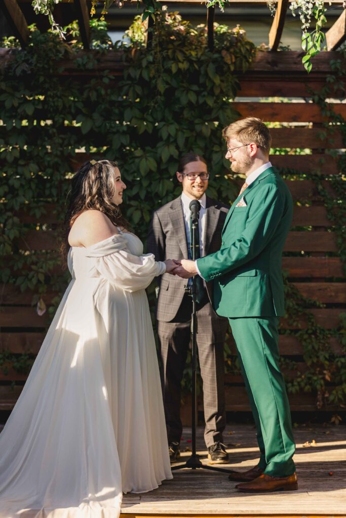 Bride and groom holding hands during their Kansas City wedding ceremony at The Magnolia Brookside. 