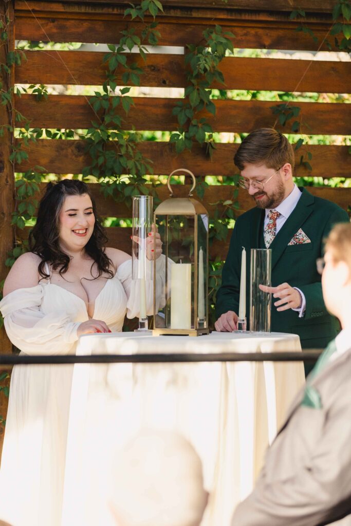 Bride and groom lighting candles during their Kansas City wedding ceremony at The Magnolia Brookside.