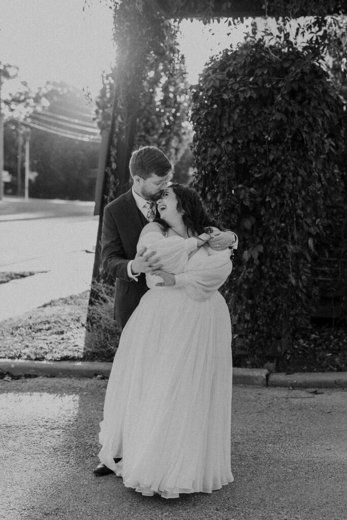 Groom holding his wife for romantic portraits at The Magnolia Brookside.