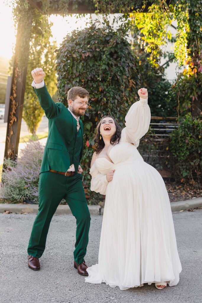 Bride and groom with their hands in the air for a funny pose at The Magnolia Brookside.