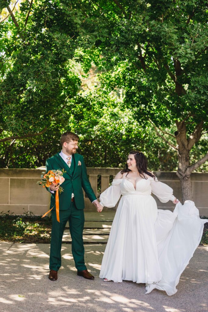 Bride and groom holding hands during wedding portraits.