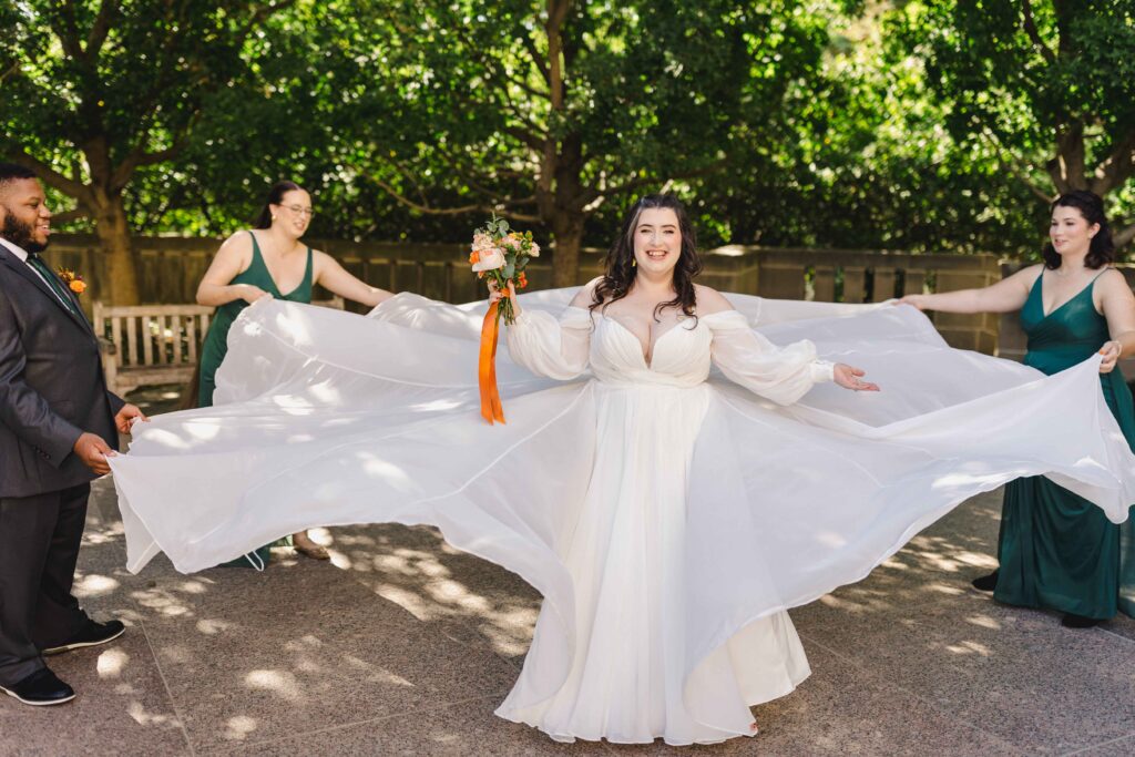 Bridal party helping the bride lay out her dress. 