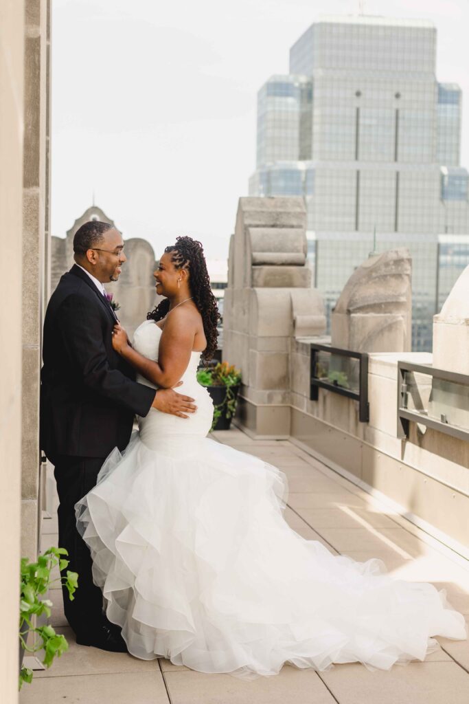 Bride and groom leaning against the wall on the rooftop of The Grand Hall at Power & Light.