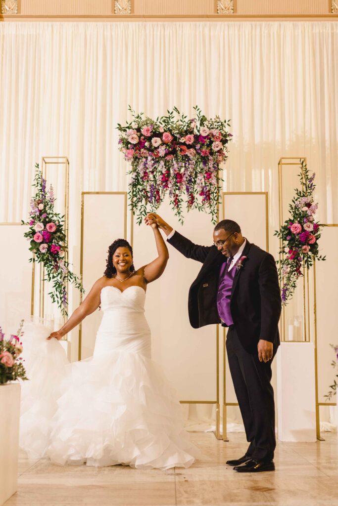 Groom twirling his bride in her pretty dress.