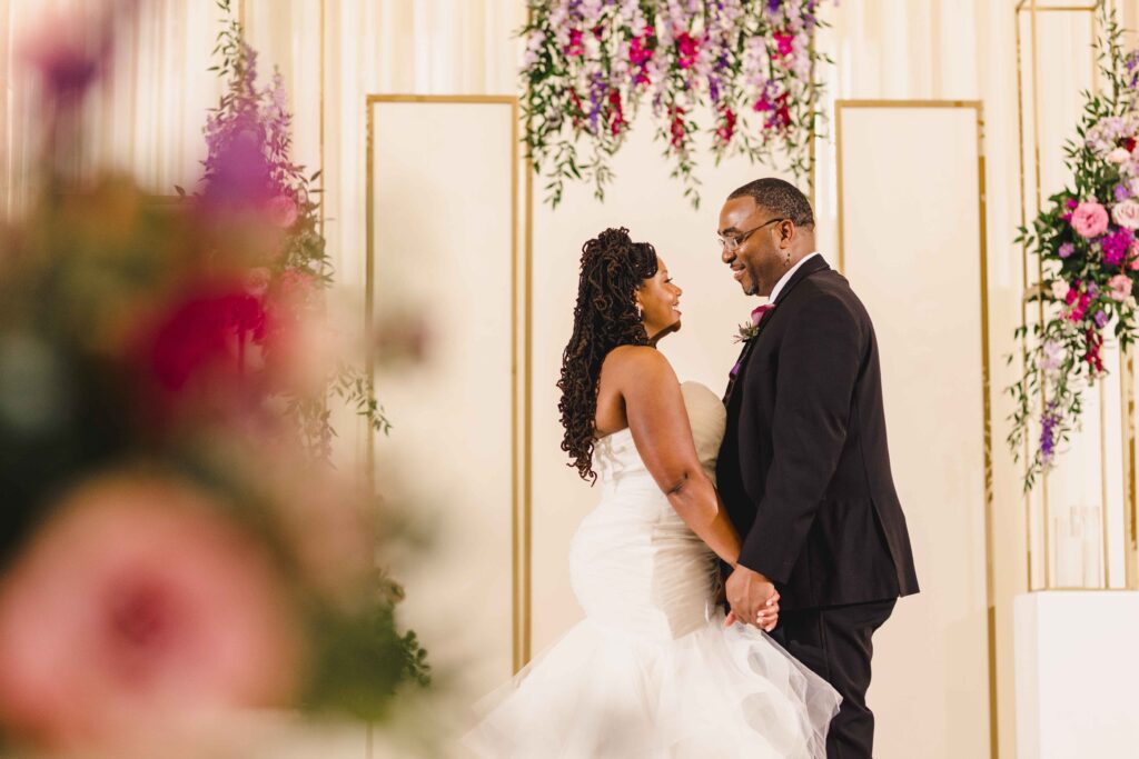 Bride and groom looking at one another romantically during wedding portraits.