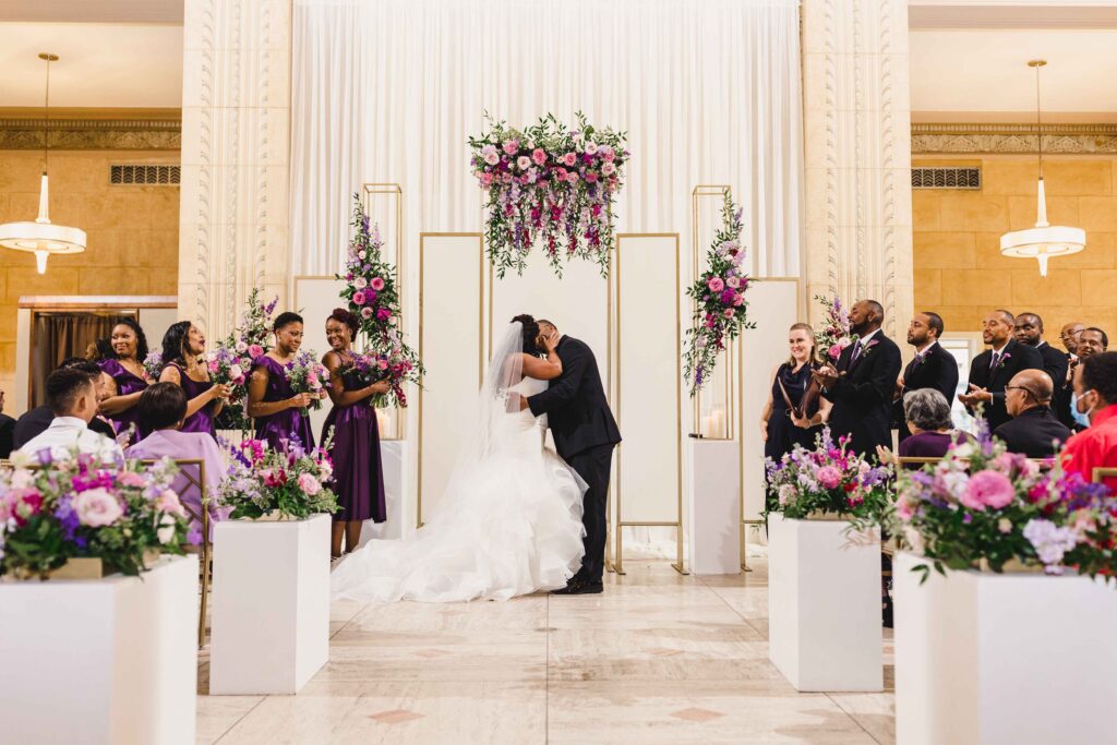 The newlyweds kissing during their wedding ceremony at The Grand Hall at Power & Light.