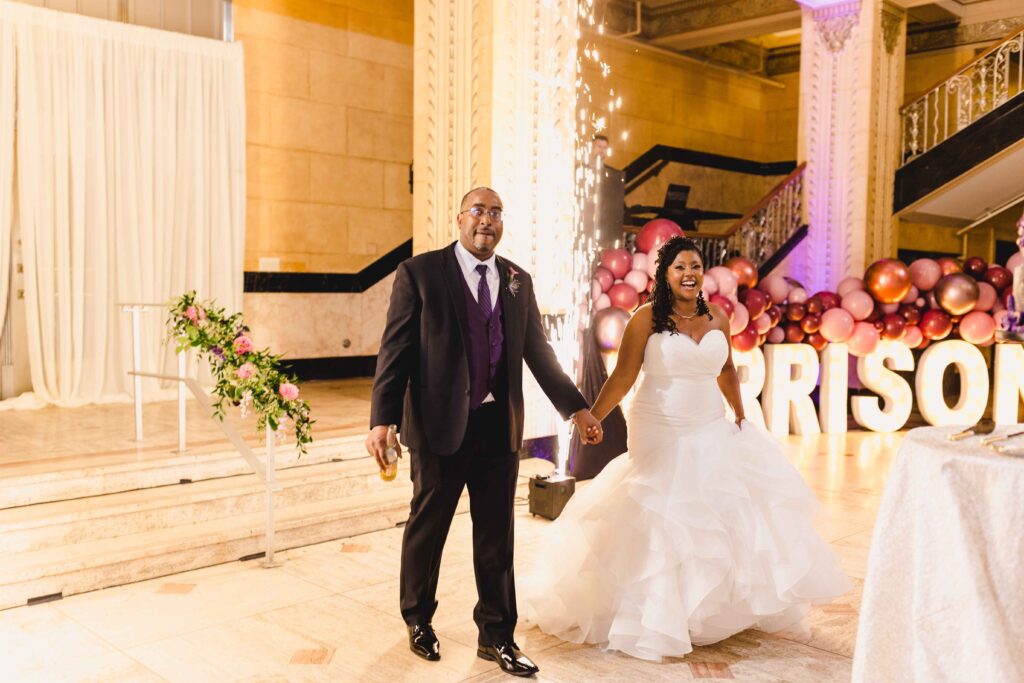 Bride and groom smiling as guests welcome them to the Kansas City wedding reception.