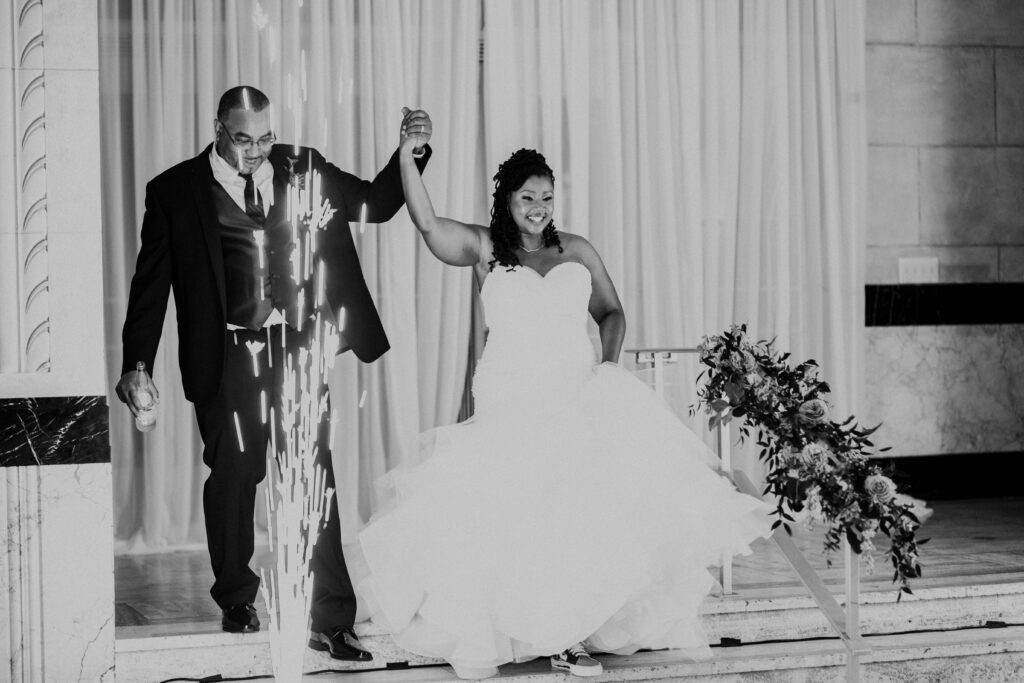 Bride and groom entering the wedding reception with sparks flying.