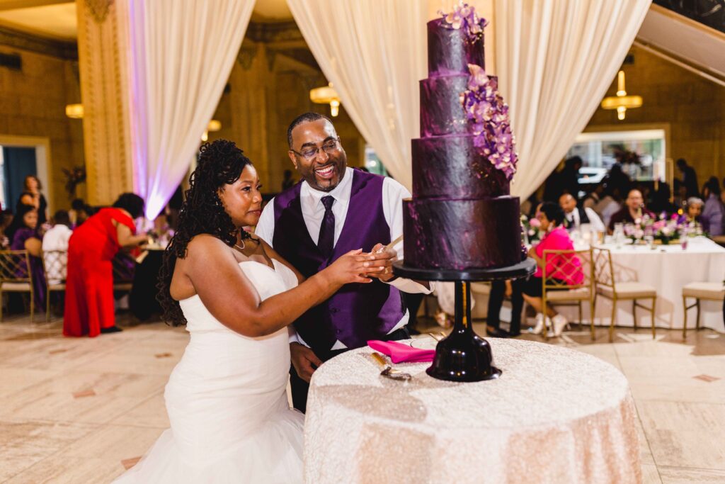Groom laughing as they cut wedding cake at The Grand Hall at Power & Light.