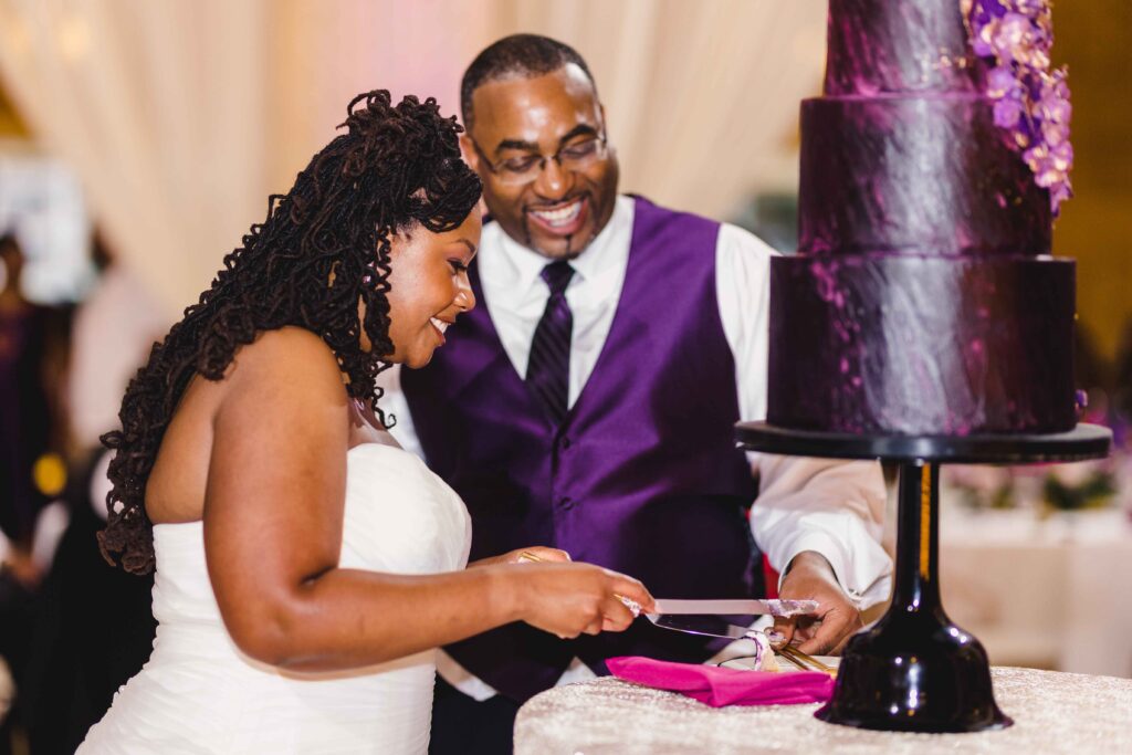 Newlyweds cutting cake for one another.
