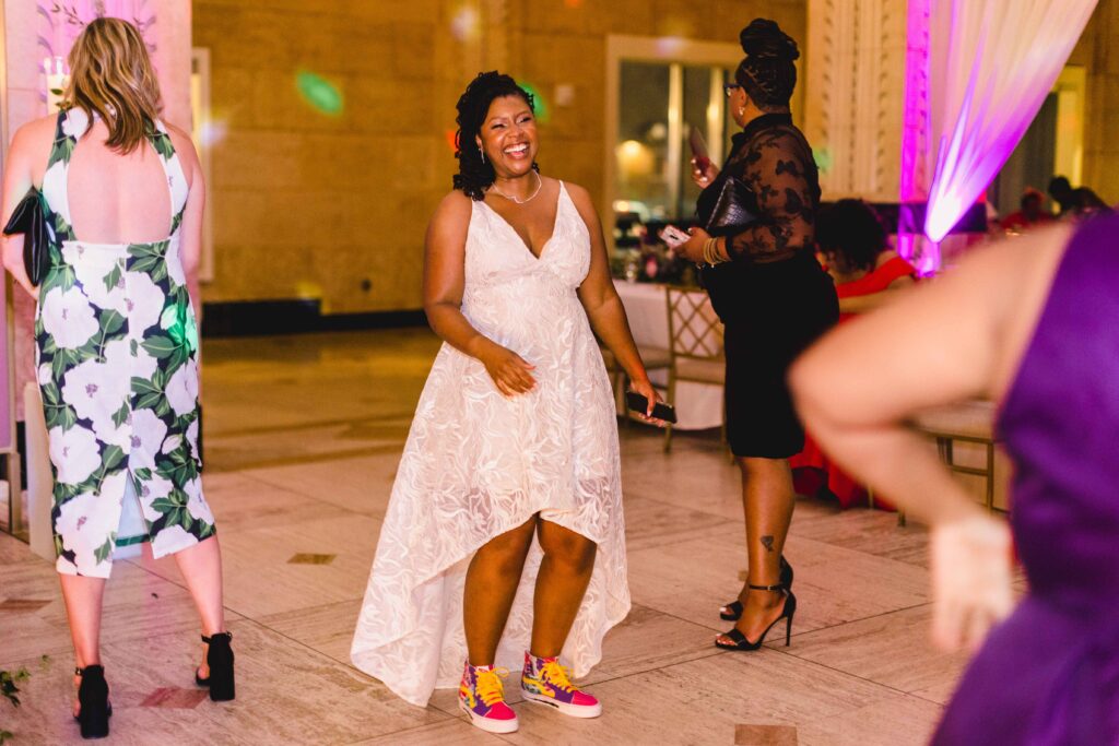 Bride wearing her reception dress and custom sneakers.