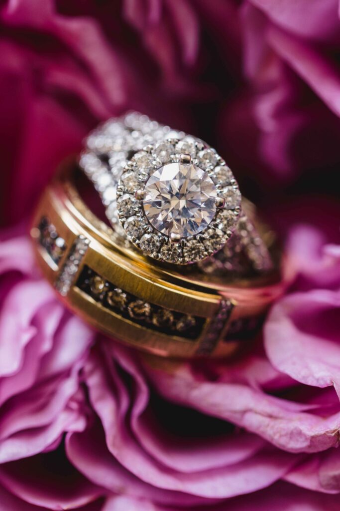 Close up of the bride and grooms wedding rings on a purple flower.