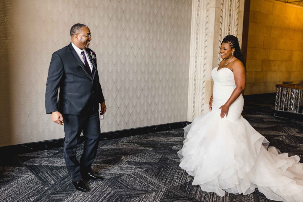 Bride and groom smiling together as they see each other for the first time.
