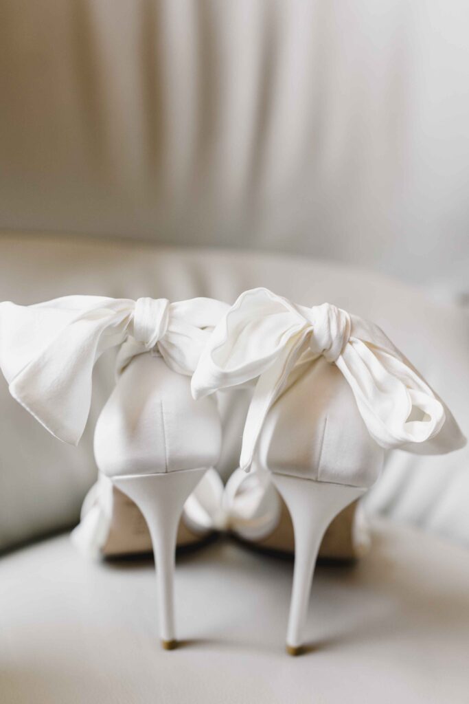 Bride's white heels with bows in the back.