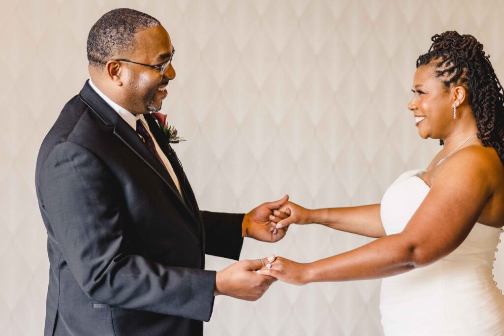 Bride and groom holding hands with big smiles at The Grand Hall at Power & Light.