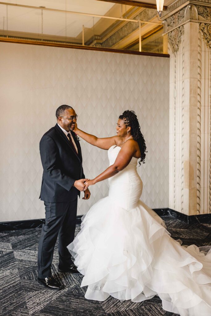 Bride touching her grooms cheek during their first look.