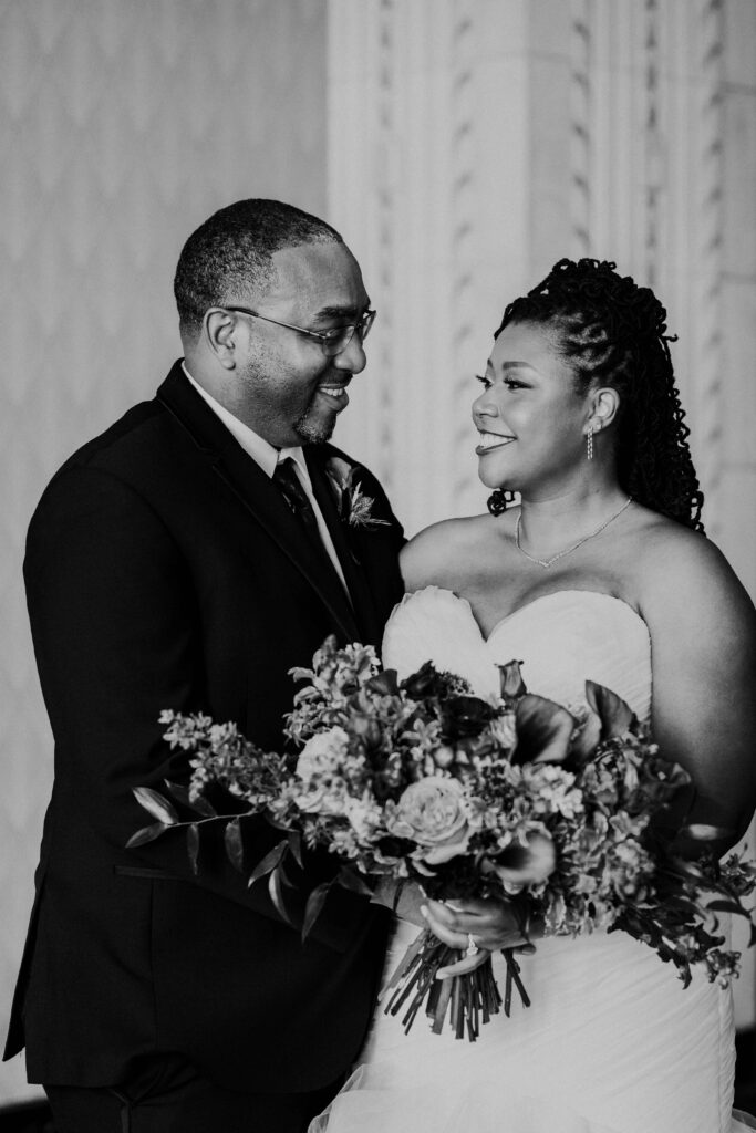 Bride and groom smiling at one another in excitement for their Kansas City wedding.
