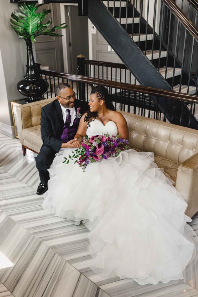 Bride and groom sitting on a couch at The Grand Hall at Power & Light.