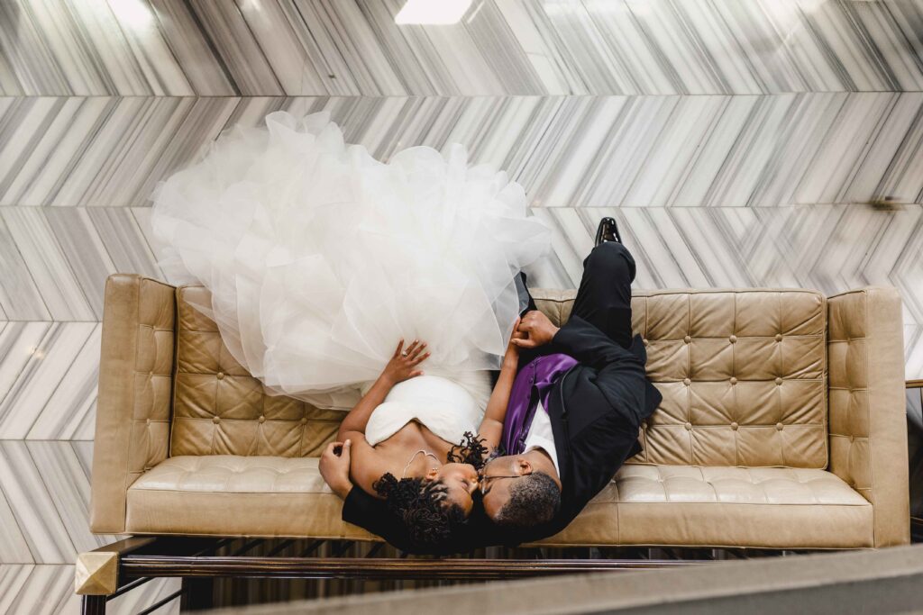 Bride and groom sitting on couch about to kiss at The Grand Hall at Power & Light.