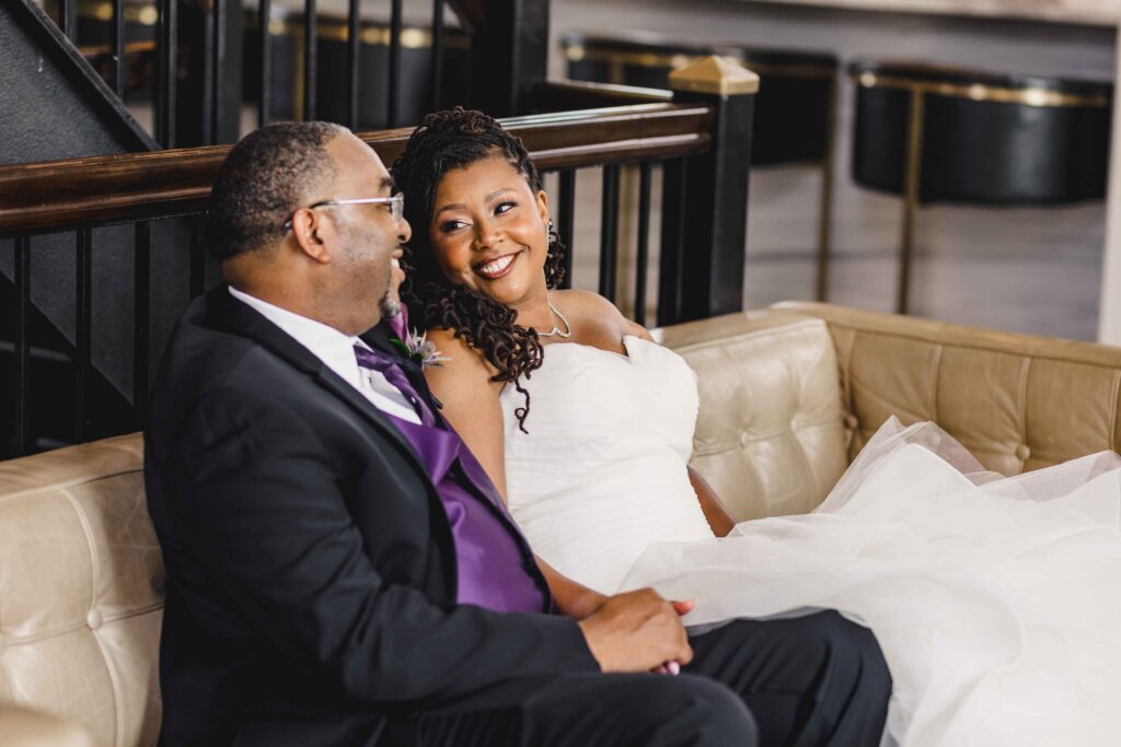 Bride and groom smiling and sitting before their ceremony.