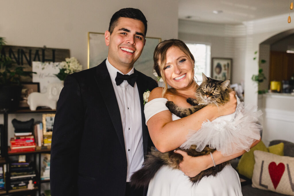 Fun wedding portraits with a cat in a wedding outfit.