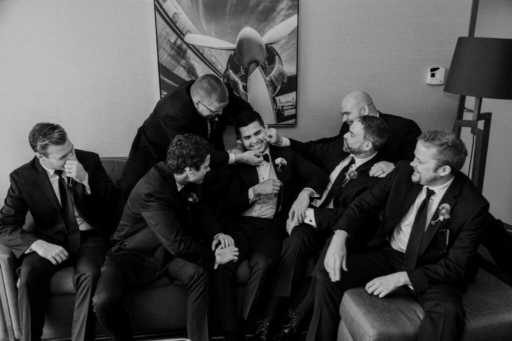 Groom and groomsmen all laughing and playing around.