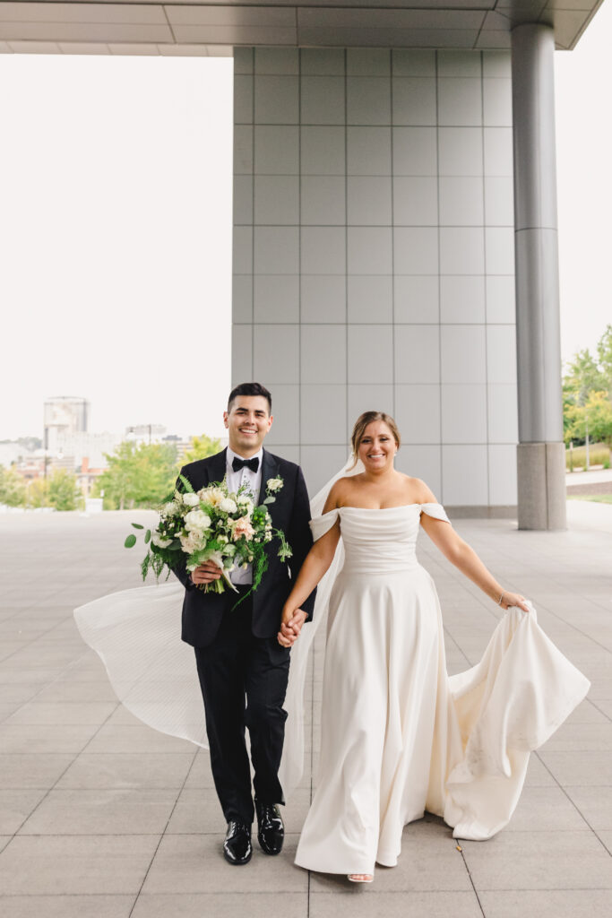 Bride and groom walking and smiling during wedding portraits.