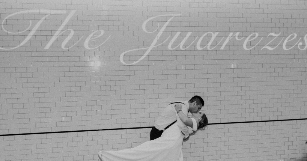 Bride and groom kissing while exiting their wedding reception at The Guild KC.