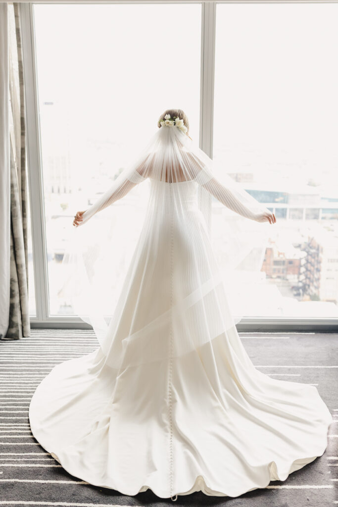 Bride in her dress from the back showcasing her veil.