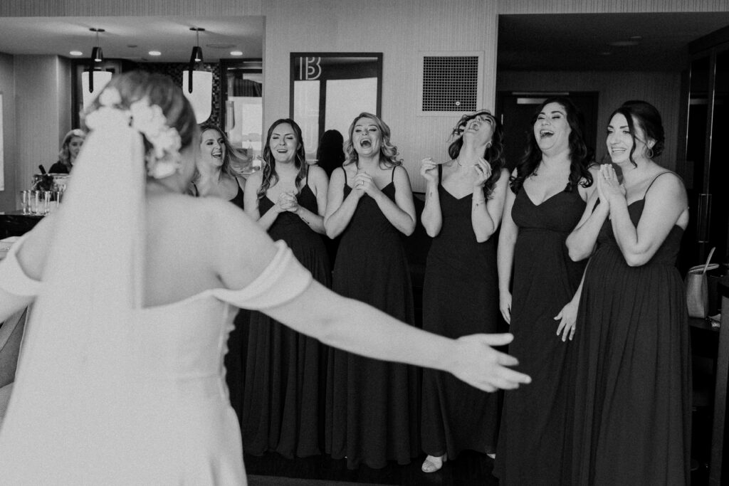Bridesmaids seeing the bride dressed and ready for the wedding.