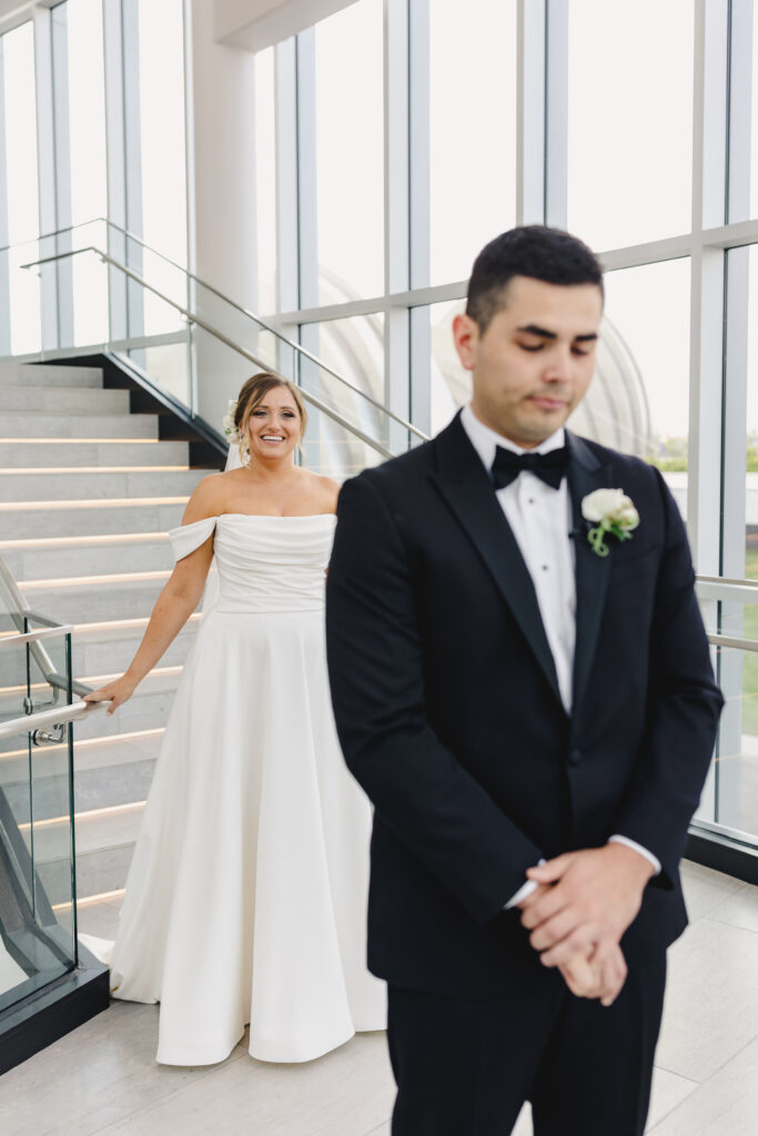 Bride standing behind the groom before their first look.