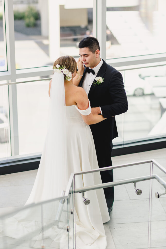 Bride holding her groom's face during their first look.
