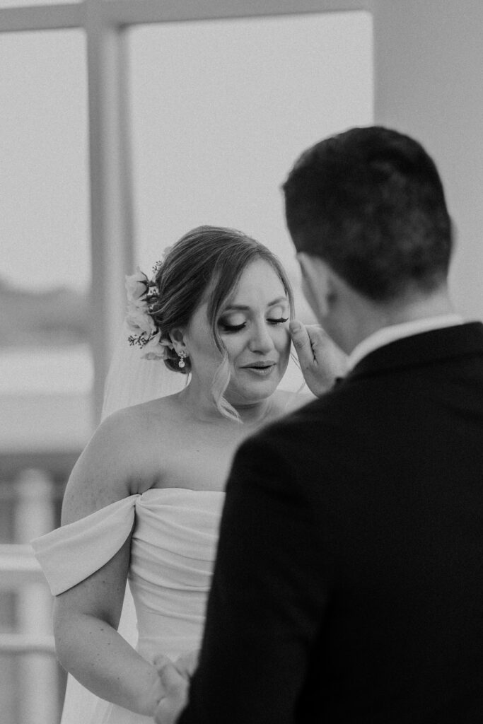 Groom wiping the bride's tears.