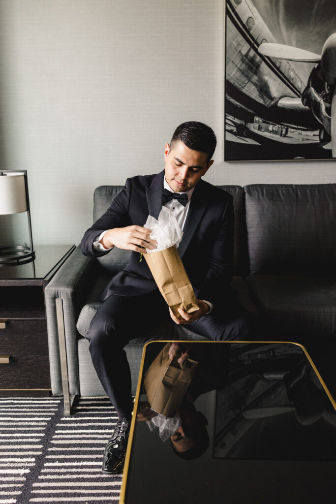 Groom opening a gift before the wedding reception at The Guild KC.