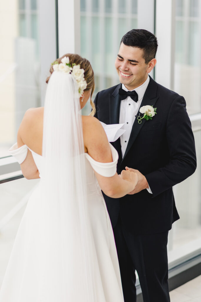 Groom smiling really big at his bride.