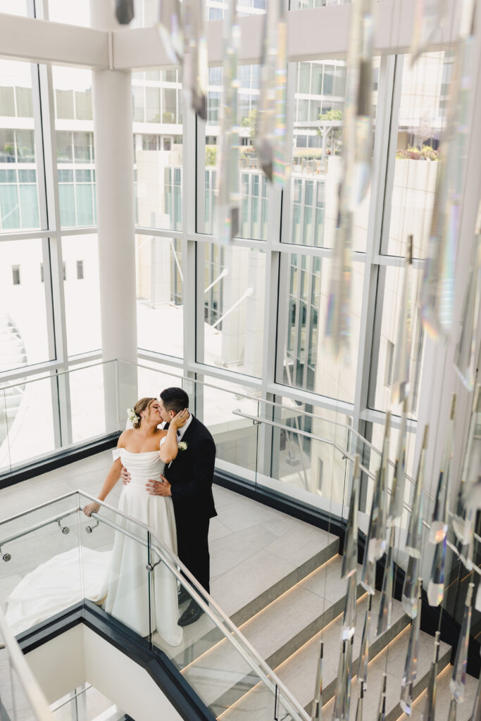 Bride and groom kissing in the stairwell of Loews Kansas City Hotel.