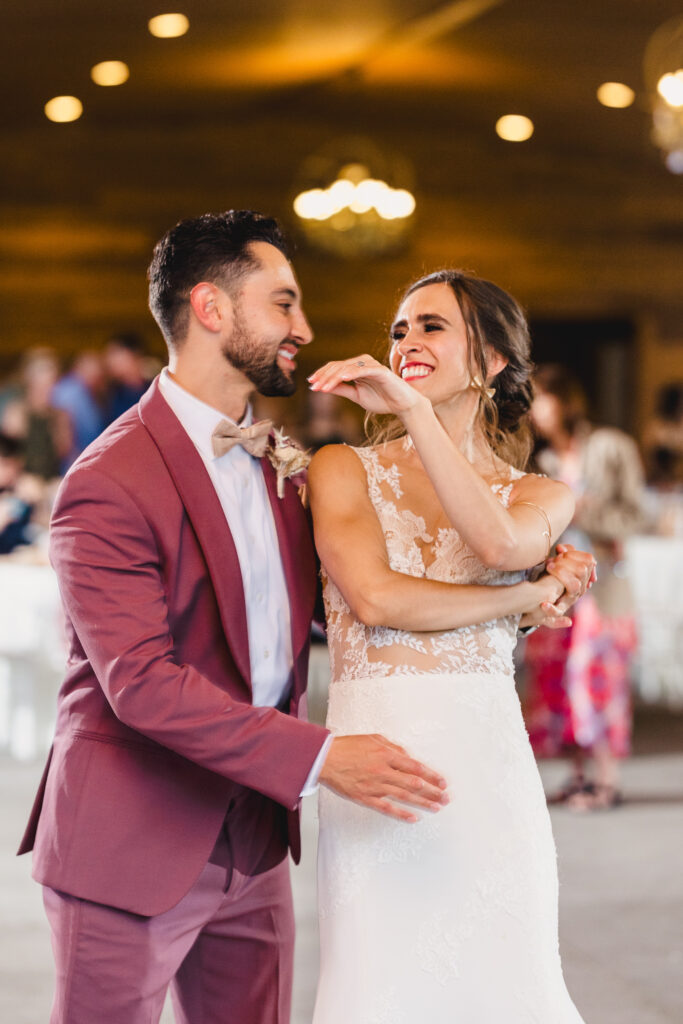 bride and groom smiling while dancing at kansas city wedding