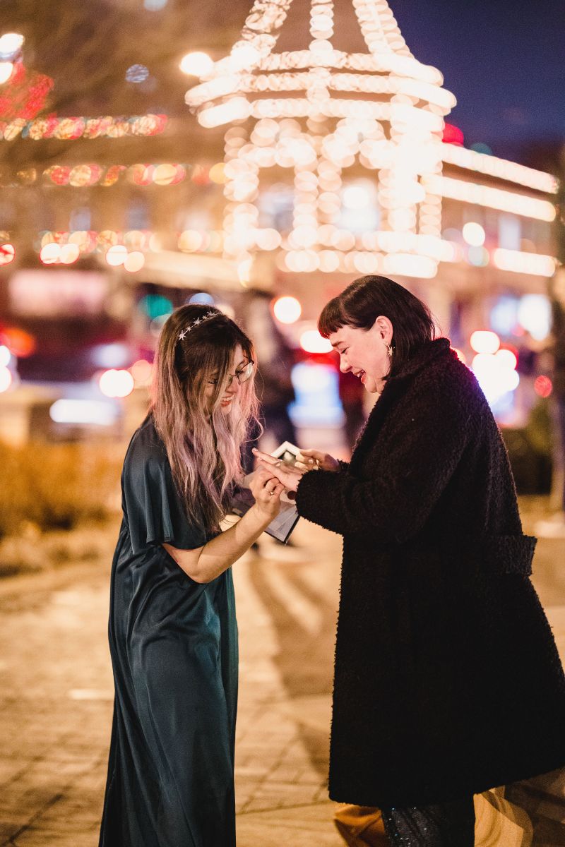 a woman accepting a ring from her partner after her partner proposed to her