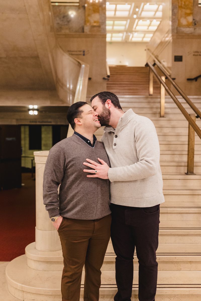 a couple taking couple portraits after a surprise proposal inside of a museum