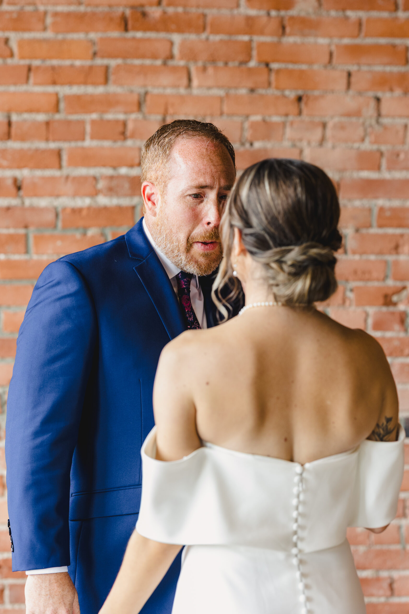 a father talking to his daughter after sharing a first look with her on the day of her wedding 