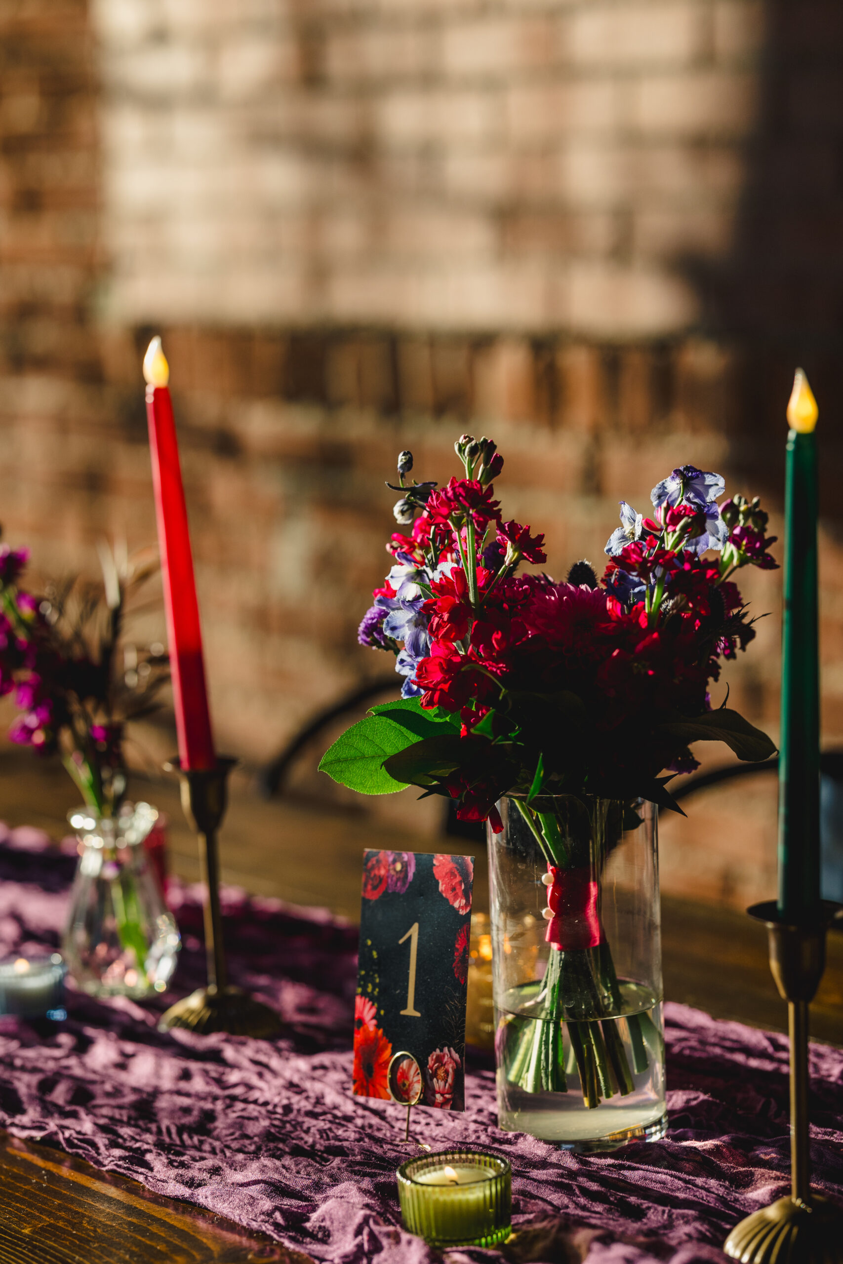 a wooden table inside of union in kansas city with a purple tablecloth, candles, and flowers in vases 