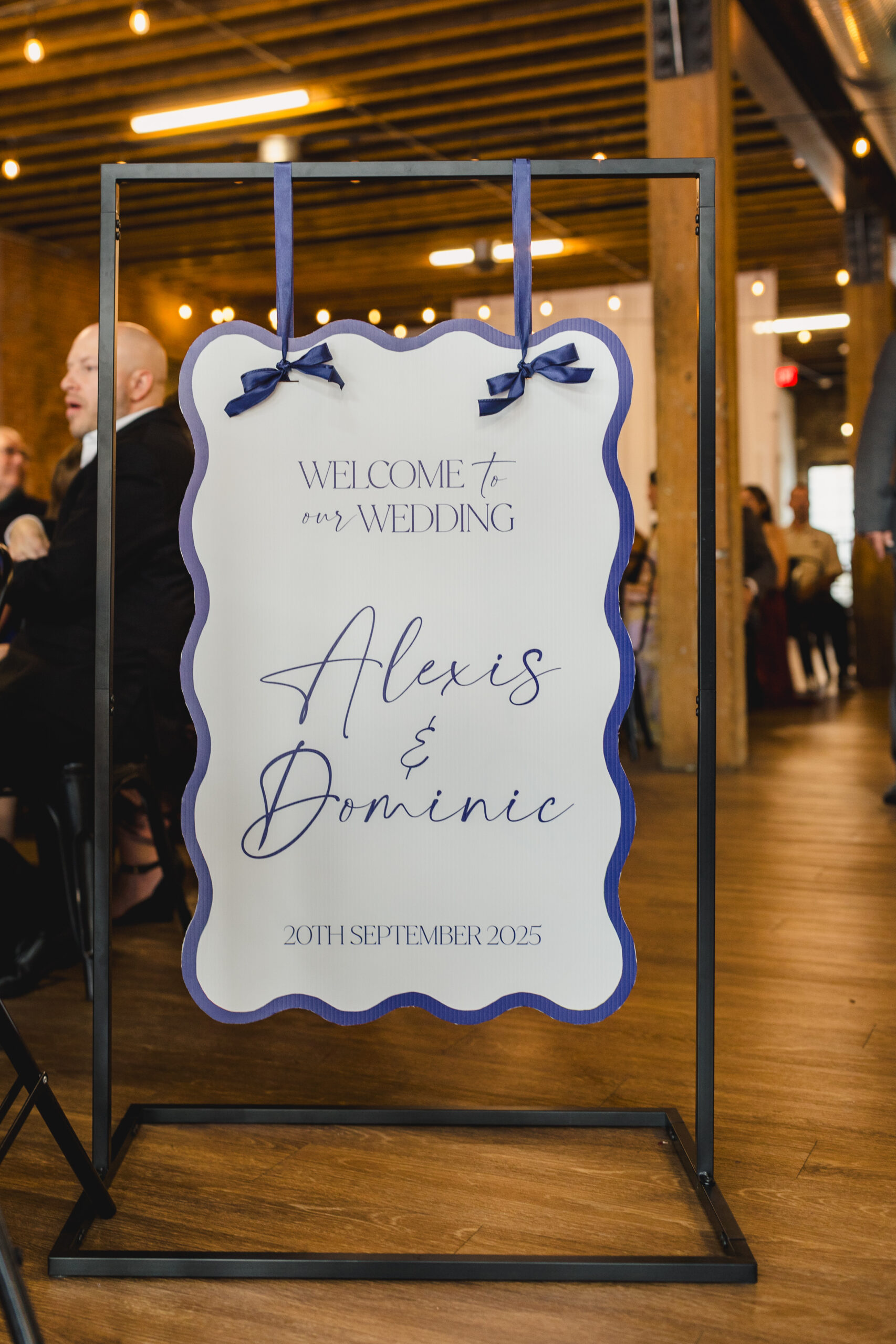 a sign that says welcome to our wedding alexis and dominic hanging in a ceremony space 