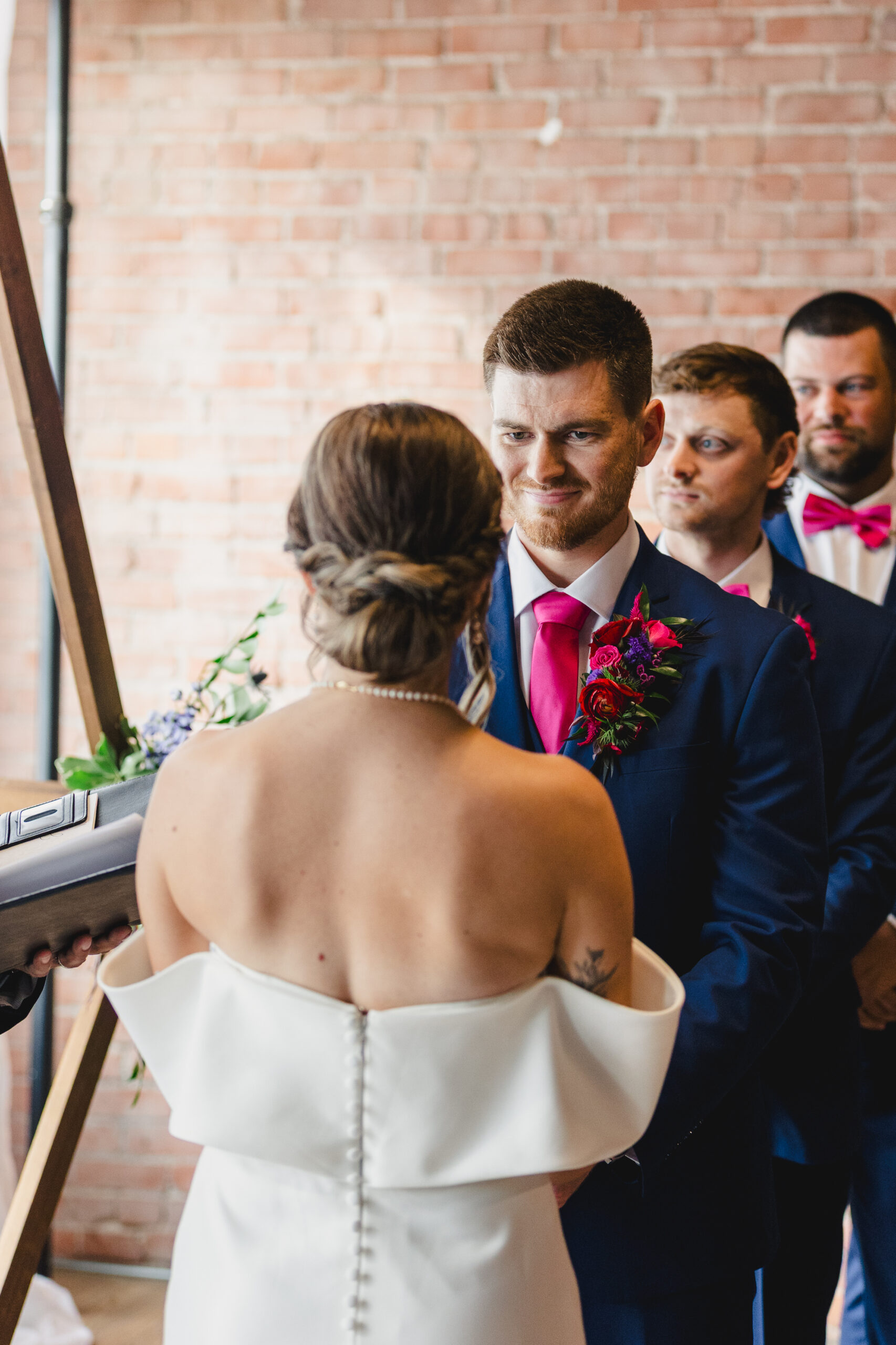a couple at their wedding ceremony looking at each other and holding hands 