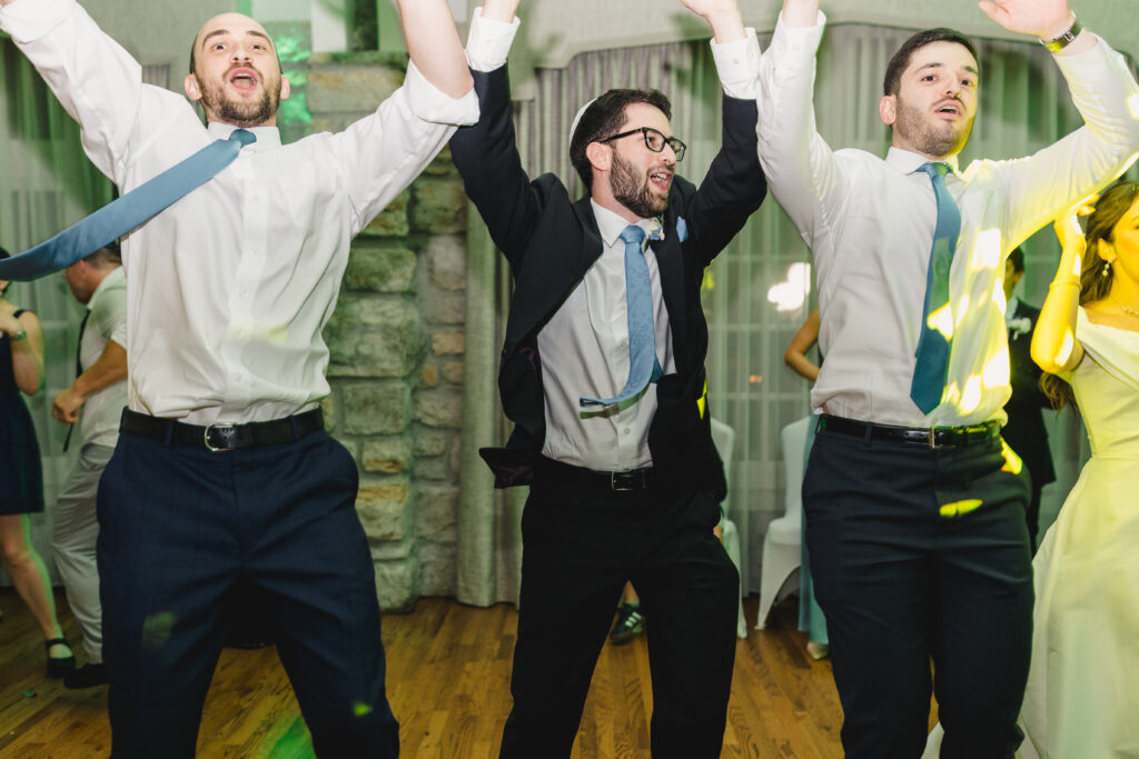 a groom dancing with his wedding guests at his wedding reception 