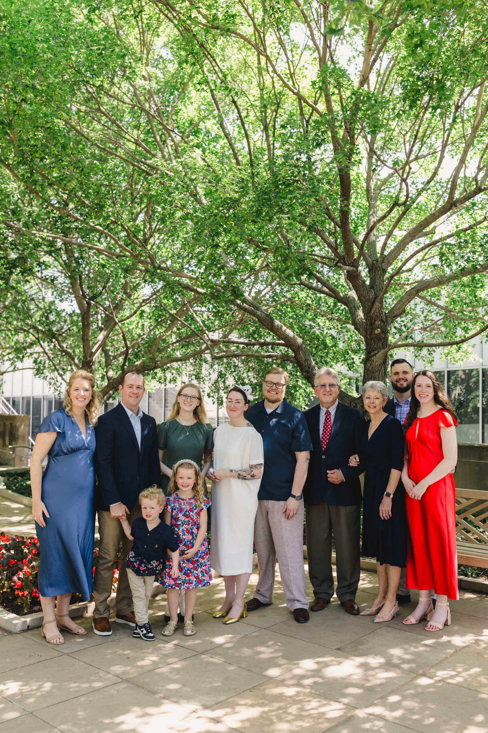 a man and woman posing with their families after their wedding ceremony