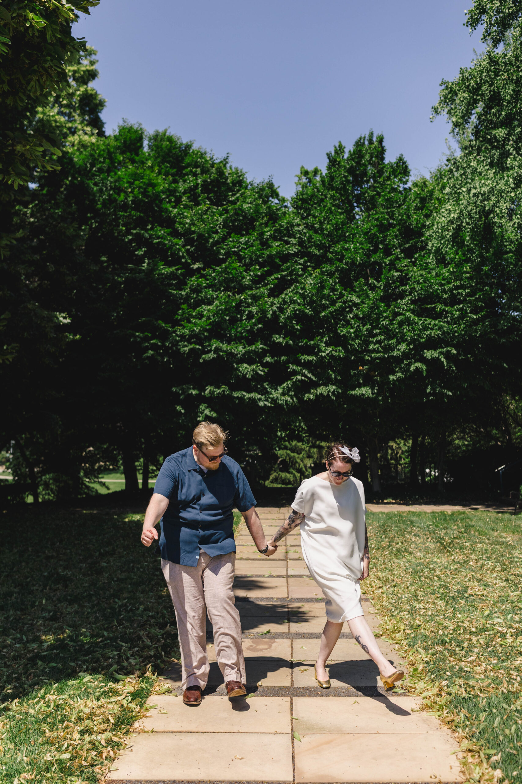 a couple walking down a sidewalk together after their wedding ceremony 