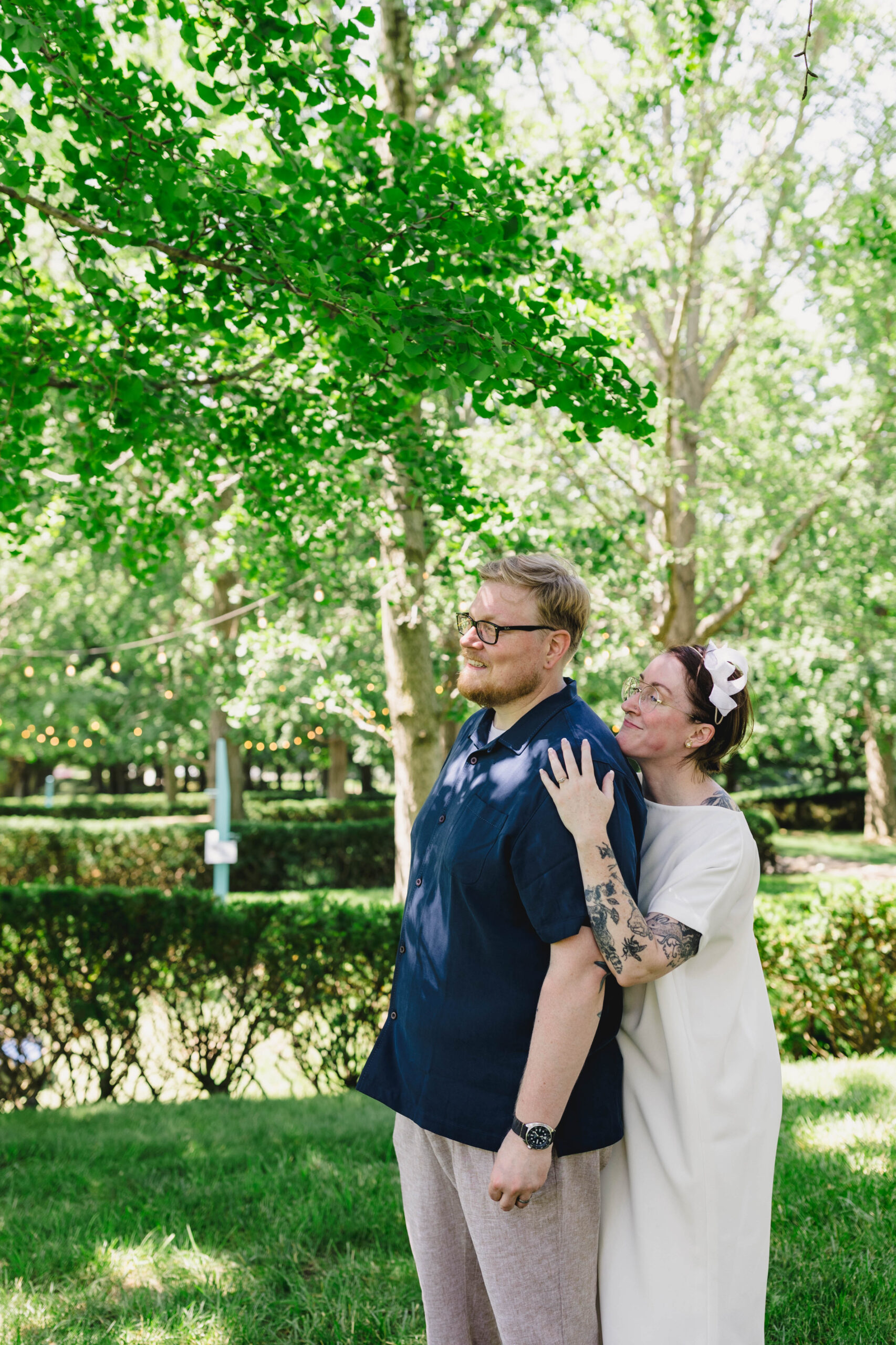 a couple taking pictures in a park after their wedding ceremony