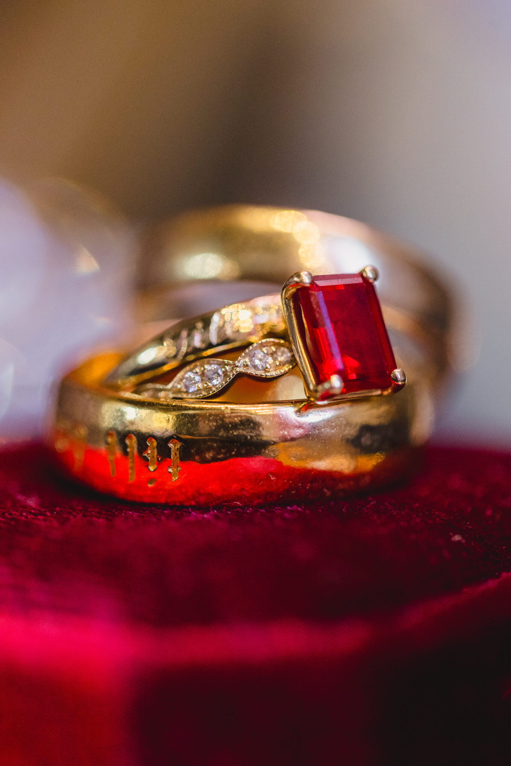 a gold wedding band and a sapphire red wedding ring 